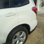 Before and after photographs of a damaged white Subaru that was repaired by Elite Paint & Body Shop in West Palm Beach, Florida